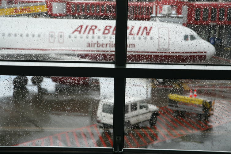 Et Air Berlin-fly kan ses gjennom et vindu fullt av regn. Foto.